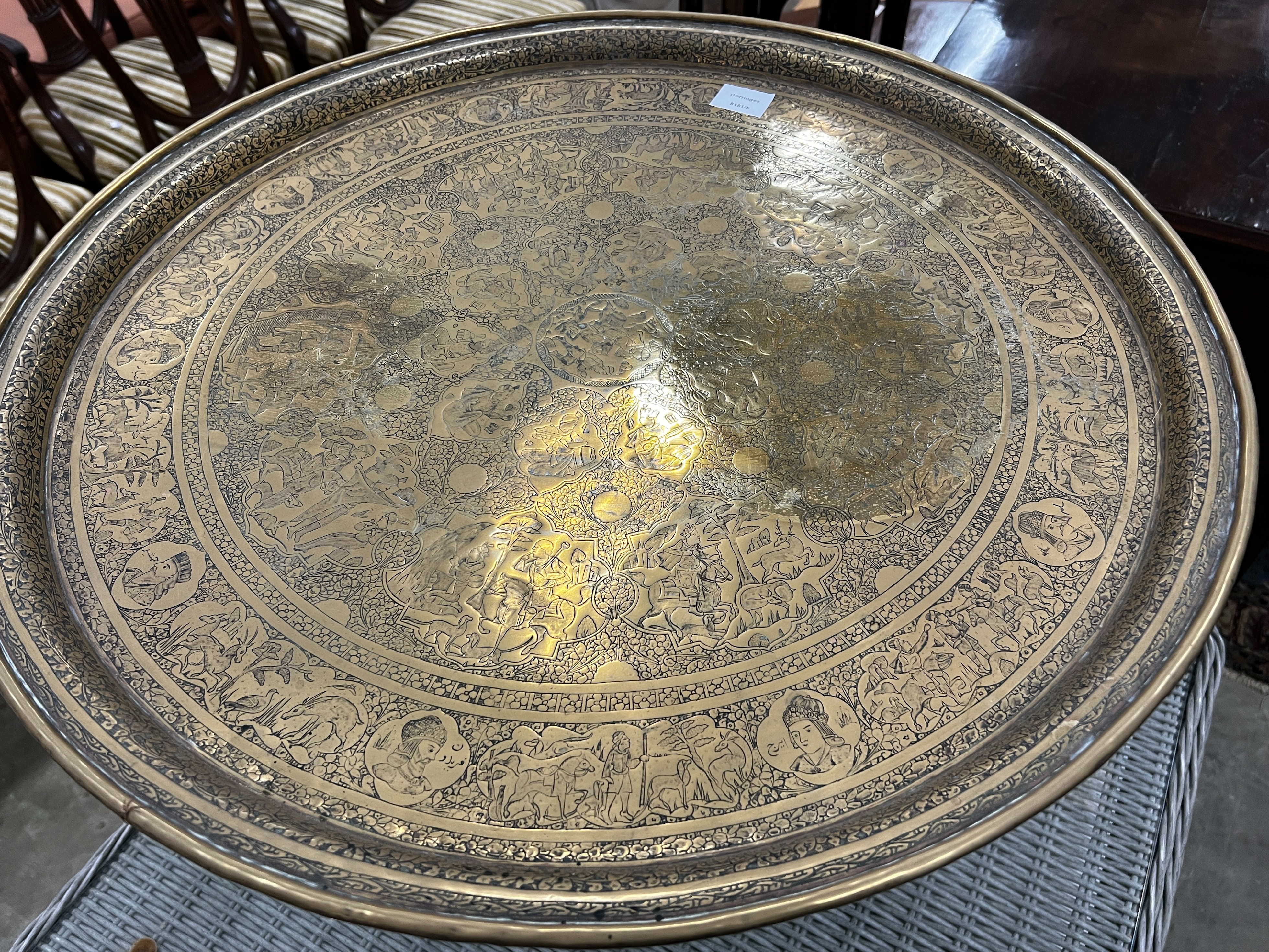 A Benares engraved brass circular tray top table on folding stand, diameter 67cm, height 59cm